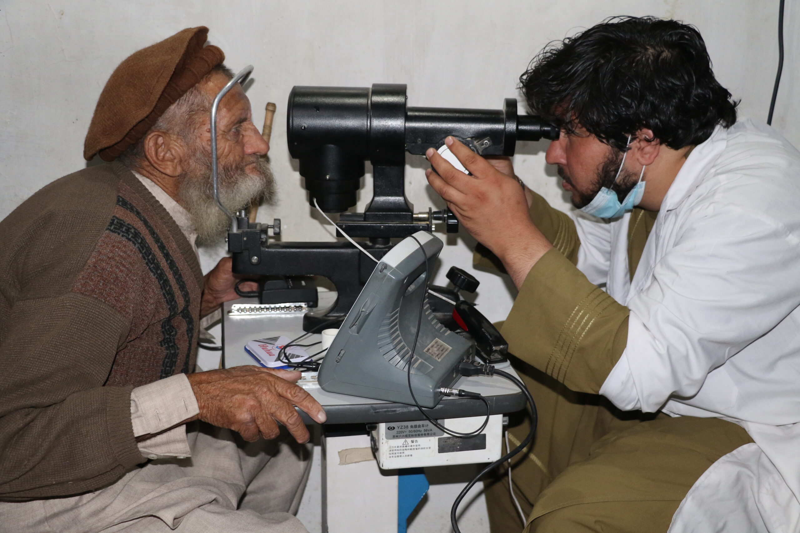 Afghan doctor checking patient's eyes